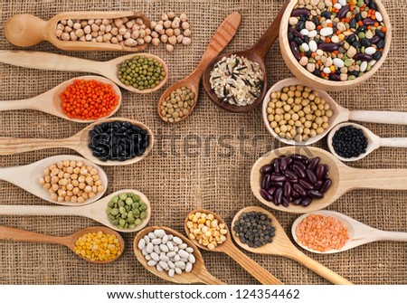 various grain, beans, legumes, peas, lentils in spoon on the sackcloth background