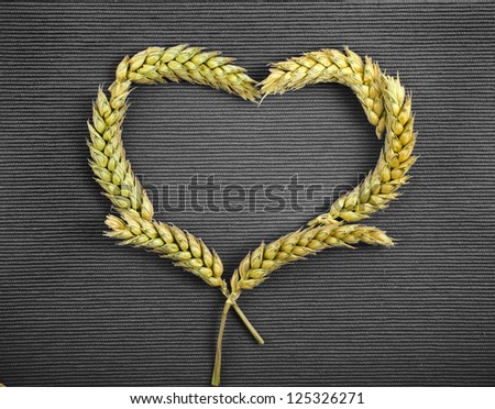 Close-up view heart symbol of wheat ears on black background