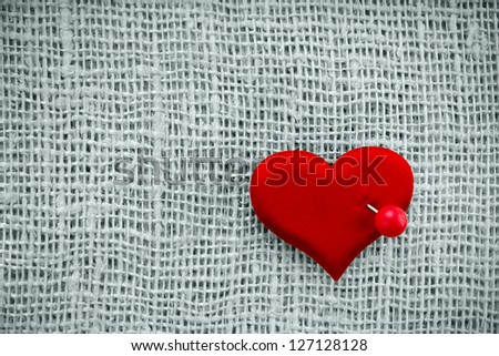 Valentine\'s day card, red heart symbol with needle on fabric sack texture background