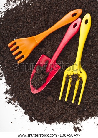 Colorful gardening tools in the soil surface corner border isolated on white background