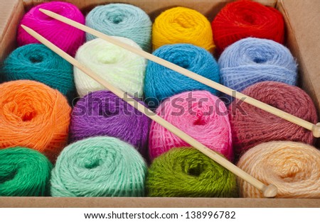 multi-colored balls of wool knitting yarn in a cardboard box