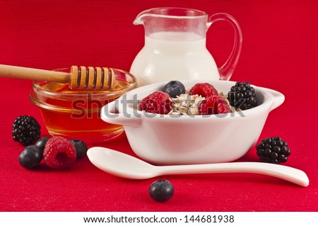 oat flake in a bowl with a fresh milk and honey on red background , diet concept