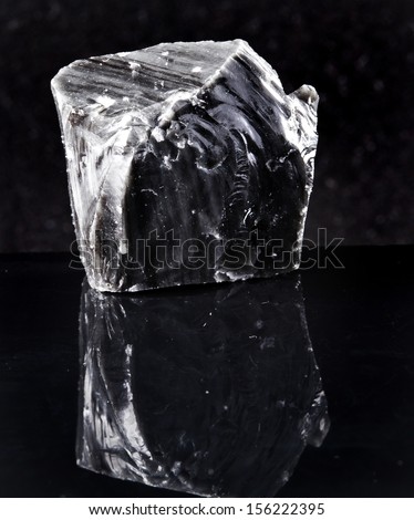 volcanic glass rock black obsidian close up macro with reflection on black background