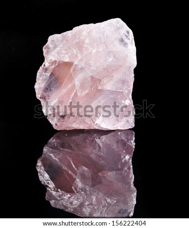 Natural Rose Quartz crystal with reflection on black surface background