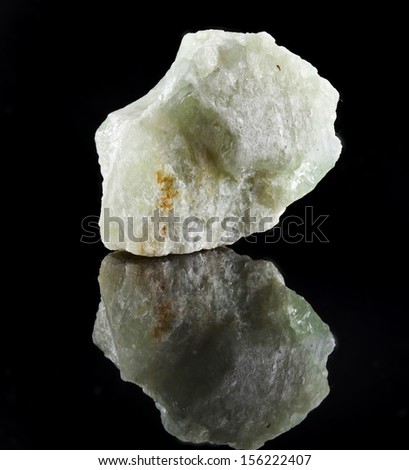 Aquamarine in rock stone with reflection on black surface background