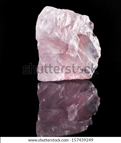 Natural Rose Quartz crystal with reflection on black surface background