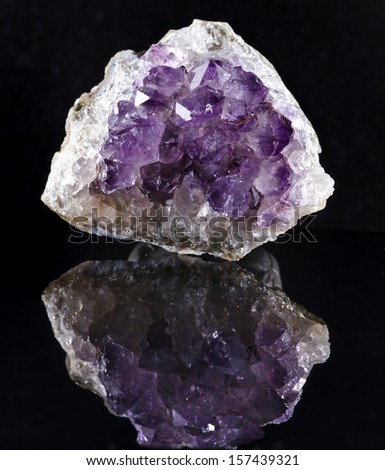 Single Natural cluster of Amethyst, violet variety of quartz close up macro with reflection on black background