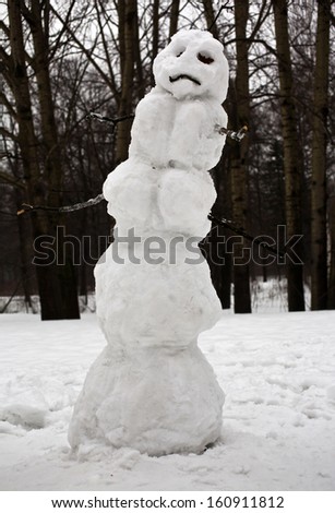 Sad Christmas snowman sitting in a snowy outdoors