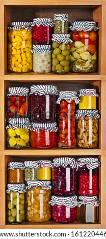 many glass bottles with preserved food in wooden cabinet Isolated on white background