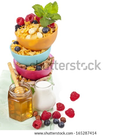 tower stack of colorful plastic bowl with fresh berries and corn flakes isolated on white background