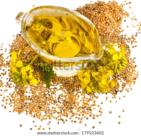 Flower Oil in gravy boat and mustard flower isolated on white background