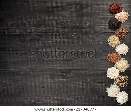 Border Frame made of colorful varieties whole grain rice in a rustic wooden surface background
