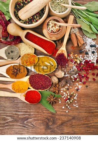Collection powder spices on spoons in wooden table surface top view background
