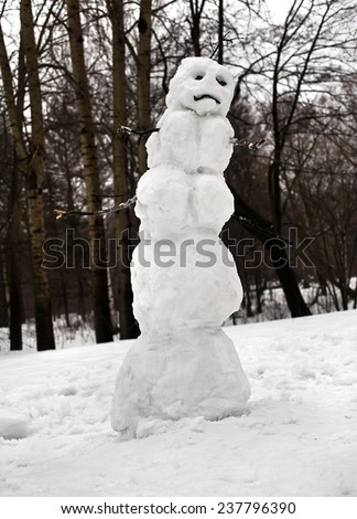 Sad Christmas snowman sitting in a snowy outdoors