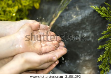 Hands catching clean falling water