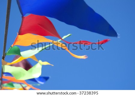 Colored Small triangular waving flags blowing in the wind on blue sky background
