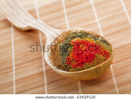 spice powder mix in a wooden spoon on a bamboo napkin