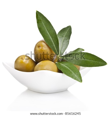 pickled green olives in a bowl and olive tree branch on a white background pickled green olives in a bowl and olive tree branch on a white background