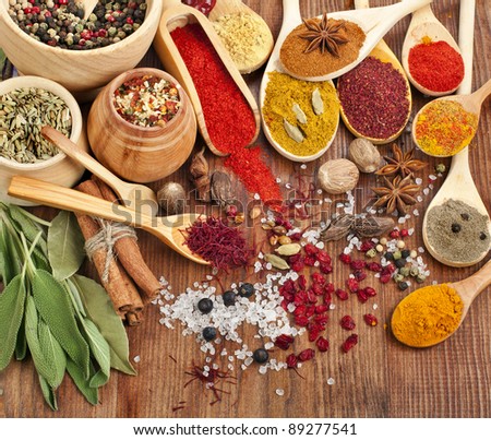 Powder spices on spoons in wooden background
