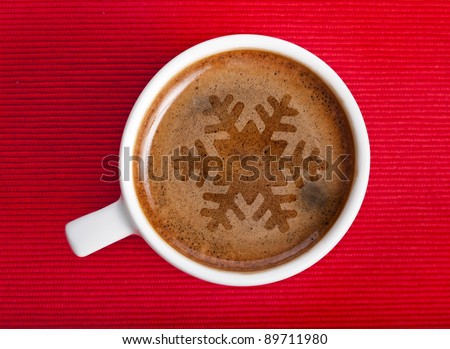 coffee cup with christmas snow flake on red napkin background