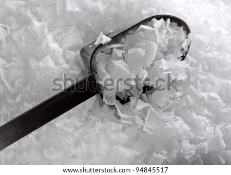 sea salt crystals flakes with spoon  textured background