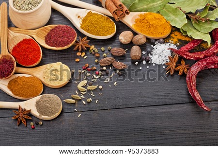 Powder spices assortment on spoons in black wooden table background