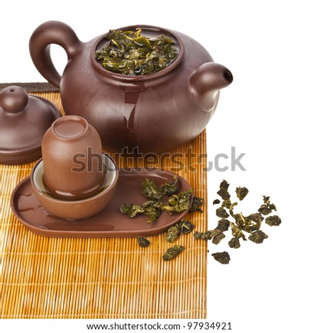 Green tea balls oolong in clay teapot and teacup isolated on white background