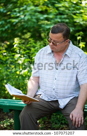 Relaxed casual man sitting in park and reading