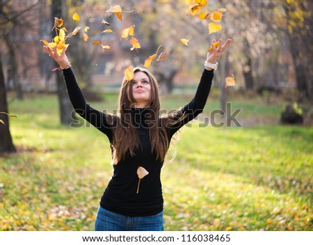 young woman throwing leaves woman in the forest