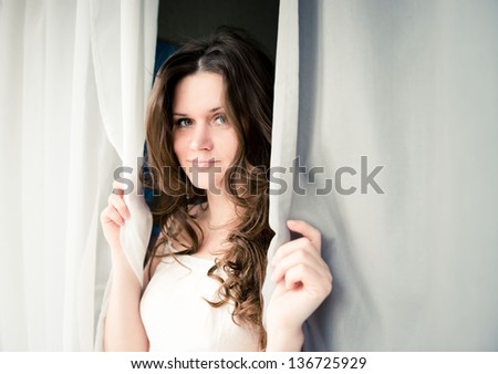 attractive young adult looking at the window with serious look