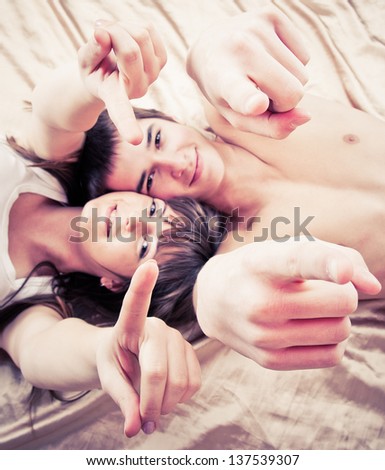 wide angle picture of a young couple pointing to you