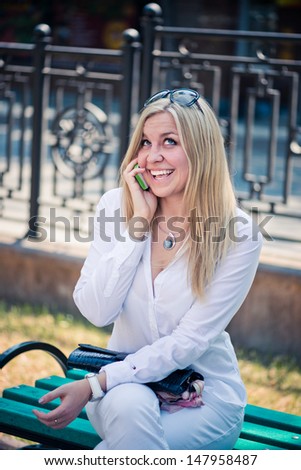 Beautiful young blond woman talk by phone outdoor