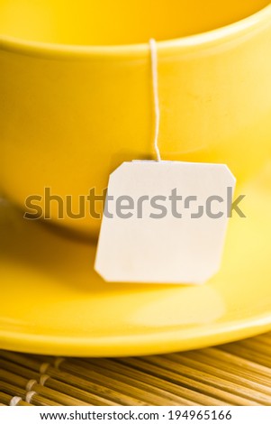 Cup of tea with tea bag (blank label) on white background