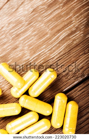 Pills spilling out on old wooden table
