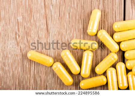 Pills spilling out on old wooden table