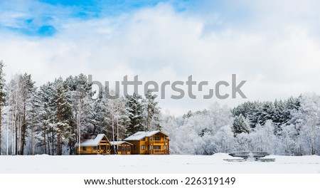 Wooden houses in a nature area covered with freshly fallen snow.