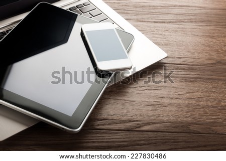 keyboard with  phone and tablet pc on wooden desk