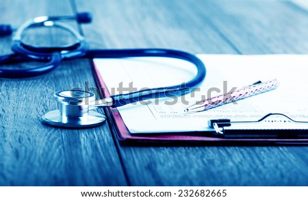 medical history with stethoscope and pen on wooden desk