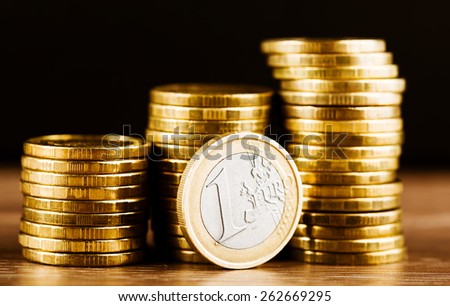 one euro coin and gold money on the desk