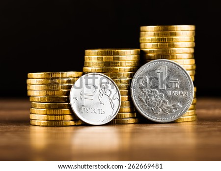 The Russian rouble coin and Chinese One Yuan Coin and gold money on the desk