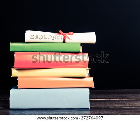 Stack Of Text Books And Graduation Scroll
