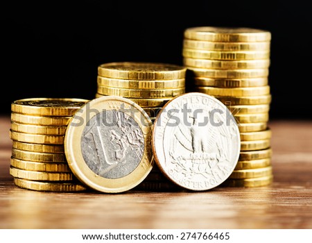 one euro coin and us quarter dollar coin and gold money on the desk