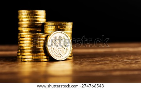 pound GBP coin and gold money on the desk