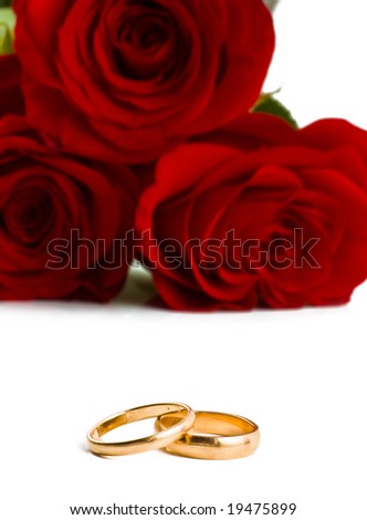 stock photo Two gold wedding bands beside a red roses