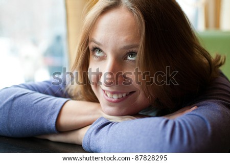 Pretty young woman leaning on a table