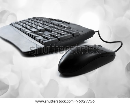 computer keyboard and mouse with lights in the background