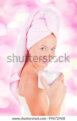 Beautiful woman tender jar of moisturizer cream  with pink lights in the background