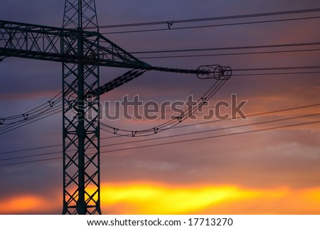Electricity pylon silhouette in the evening sunset sky.