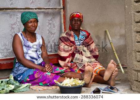 HOEDSPRUIT, SOUTH AFRICA - APRIL 17: a couple of woman while cleaning the food dressed in a typical dress of the village april 17, 2015 in Hoedspruit, South Africa