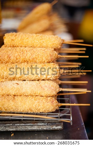 Deep fried sausage skewer battered in panko flakes. Traditional thai cuisine on a market.